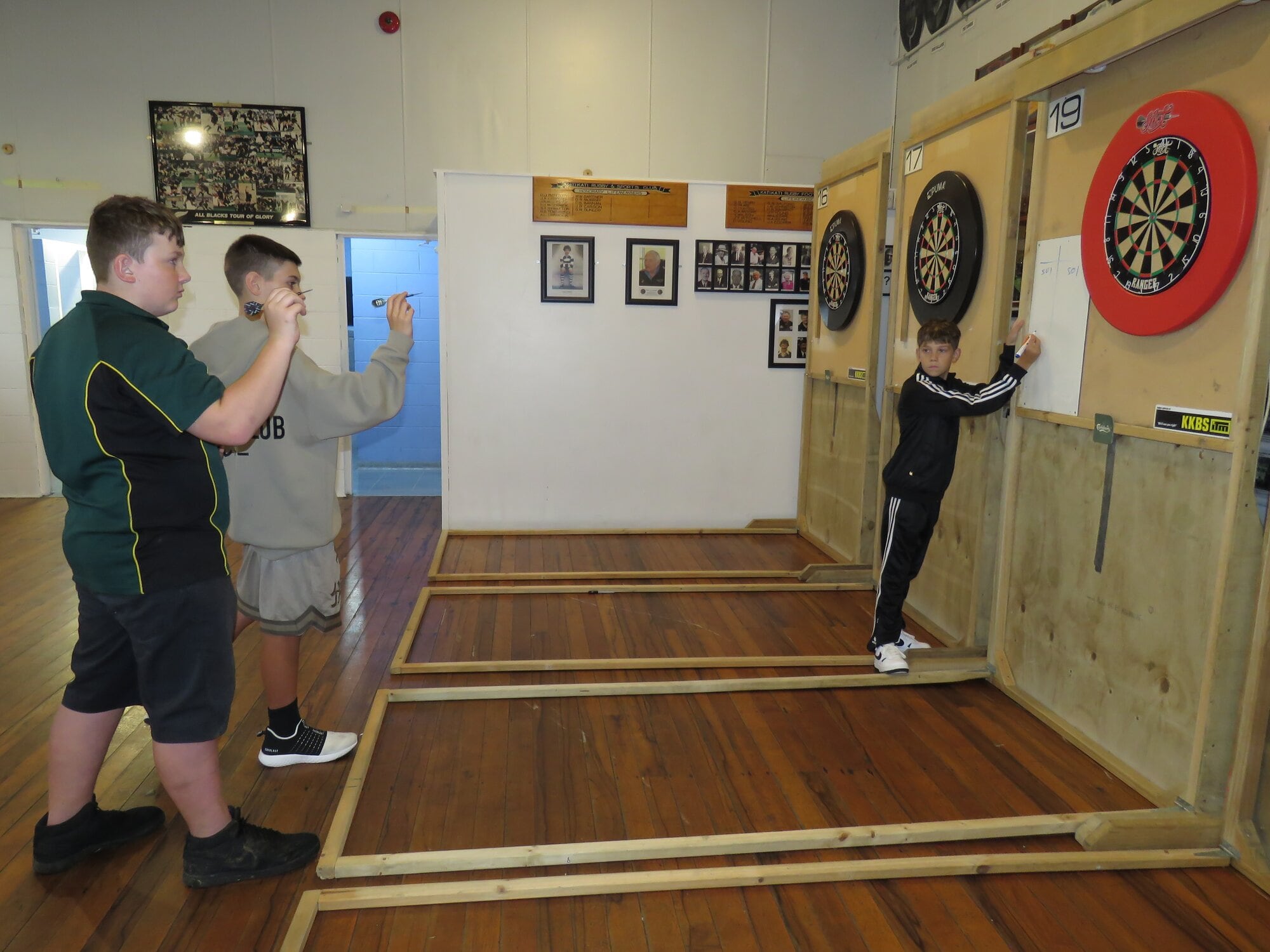  Thirteen-year-olds Corbyn Richards and JR Kruger, get ready to throw darts while Tyron Dercksen, 12, takes their scores. Photo / Merle Cave