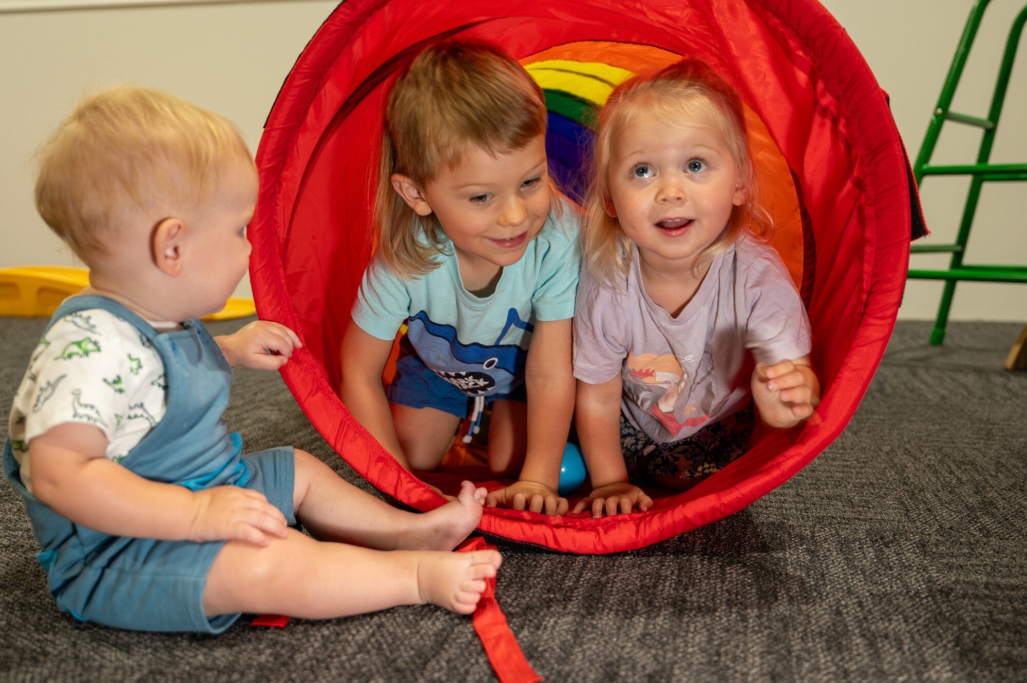  James Phillott, aged one, watches Kereama Laughton, aged four, and his sister Harriet Phillott, aged two, play in a tunnel at Minikidi. Photo / David Hall