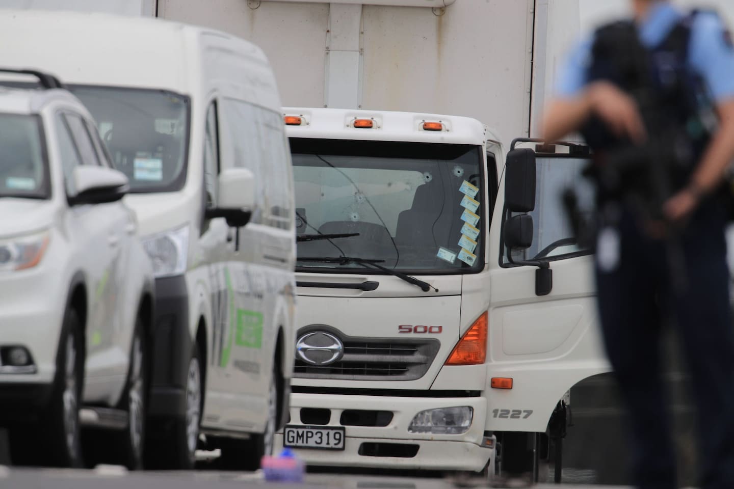 A white truck at the scene with bullet holes in its windscreen. Photo / Hayden Woodward