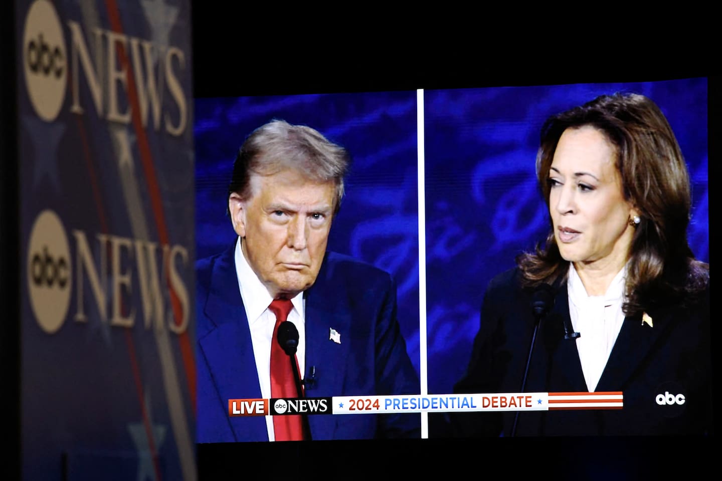 US Vice President and Democratic presidential candidate Kamala Harris and former US President and Republican presidential candidate Donald Trump are seen on a screen in the spin room as they participate in a presidential debate at the National Constitution Center in Philadelphia, Pennsylvania, on September 10, 2024. (Photo by MATTHEW HATCHER / AFP)