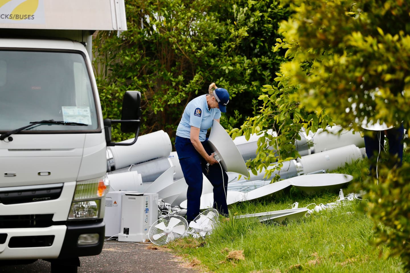 Officers dismantle and take away ducting and air filters along with light fixtures, electric fans and reflective material, from one of the properties. Photo / Dean Purcell