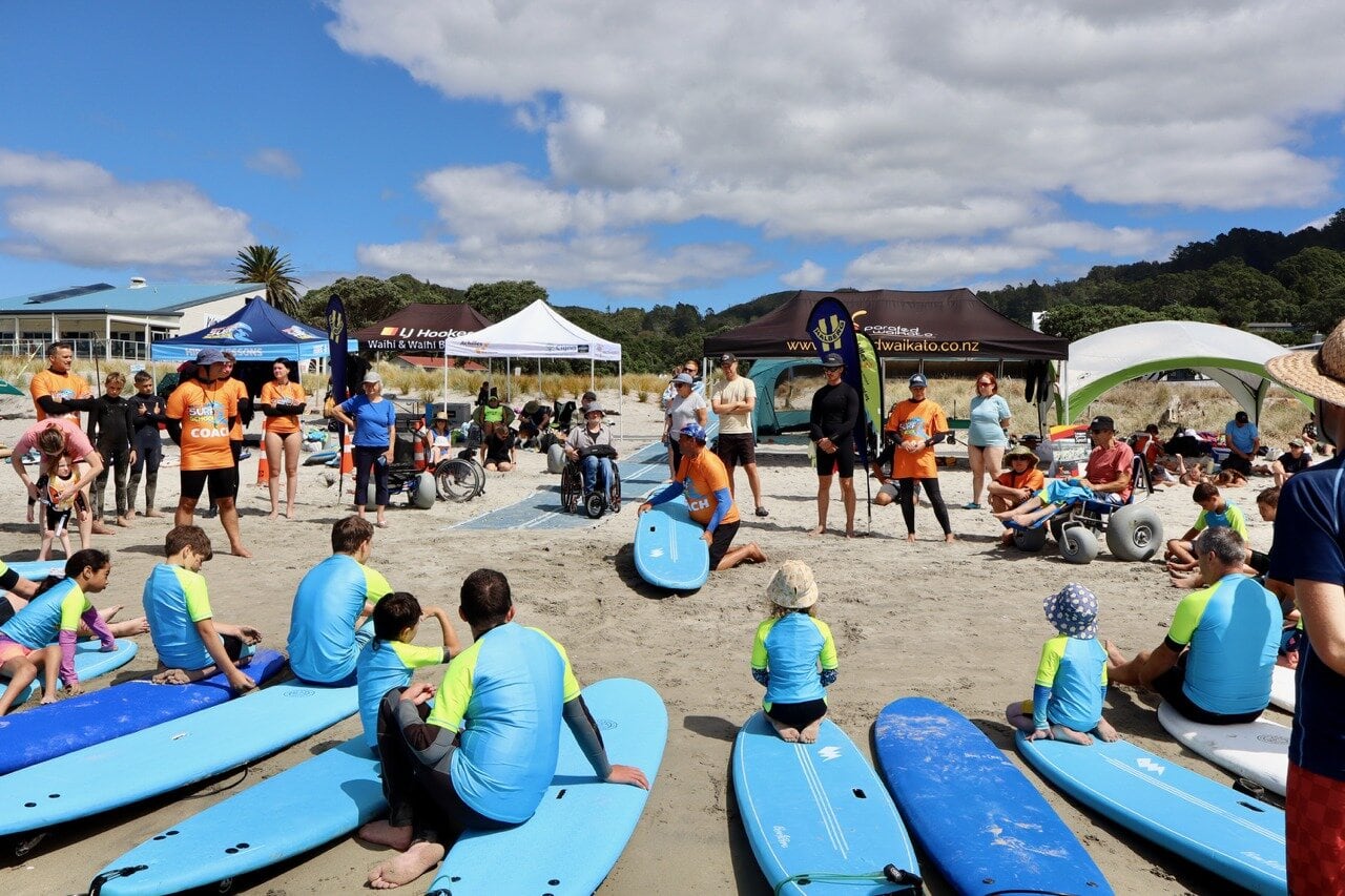 A number of participants prepare to try adaptive surfing at Waihī Beach. Photo / Supplied