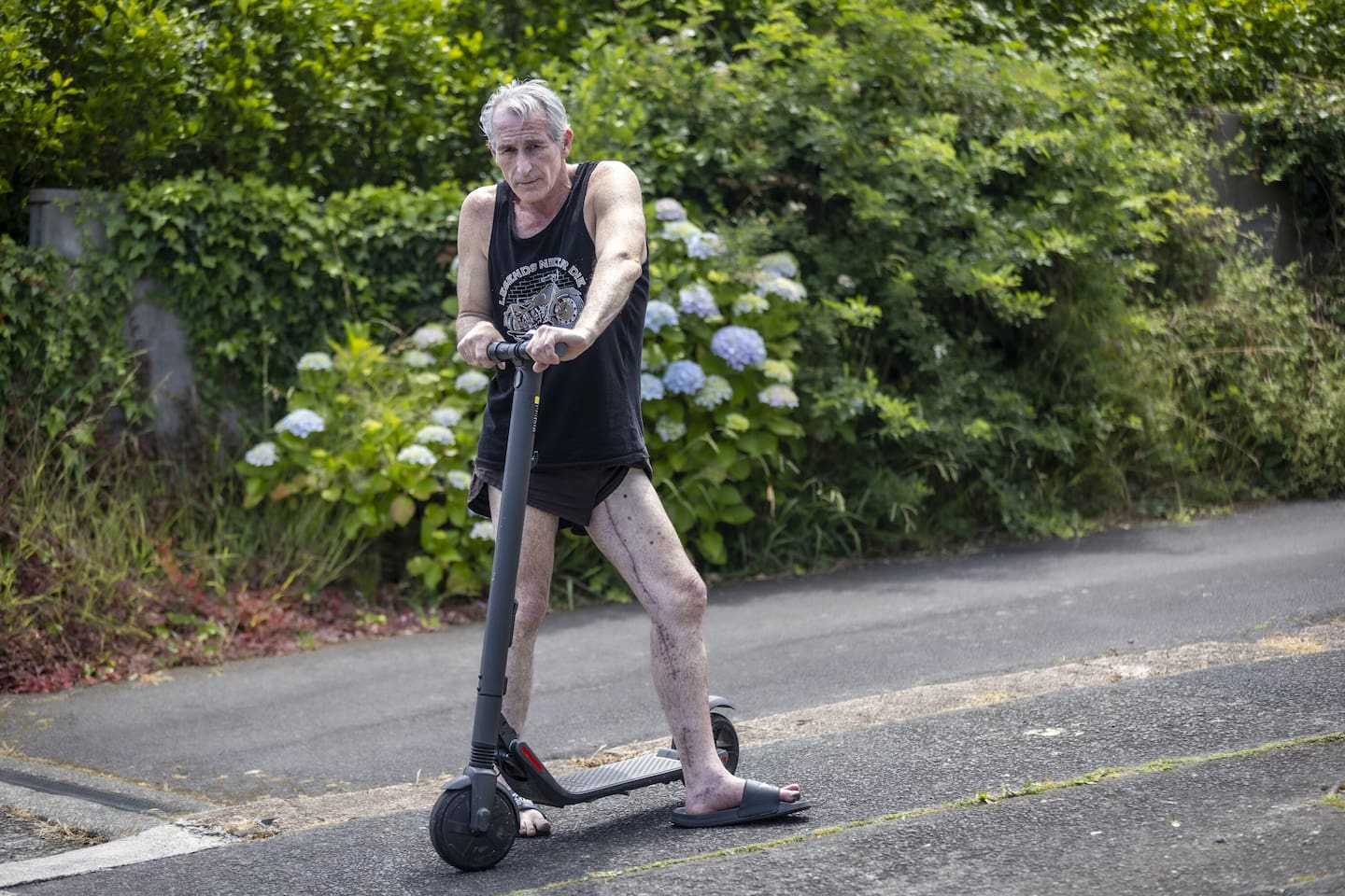 David Stewart uses a stand-up scooter to help take the weight off his injured leg. Photo / Michael Craig