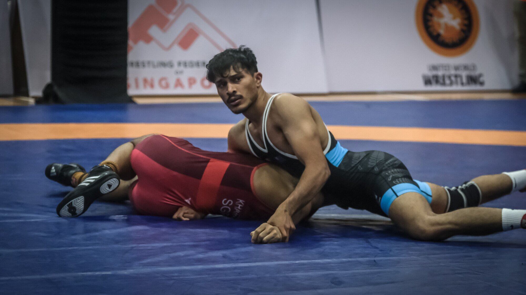  Suraj Singh, in blue, pins one of his Singaporean competitors at the 2025 Southeast Asian & Invitation Wrestling Championship. Photo / Supplied