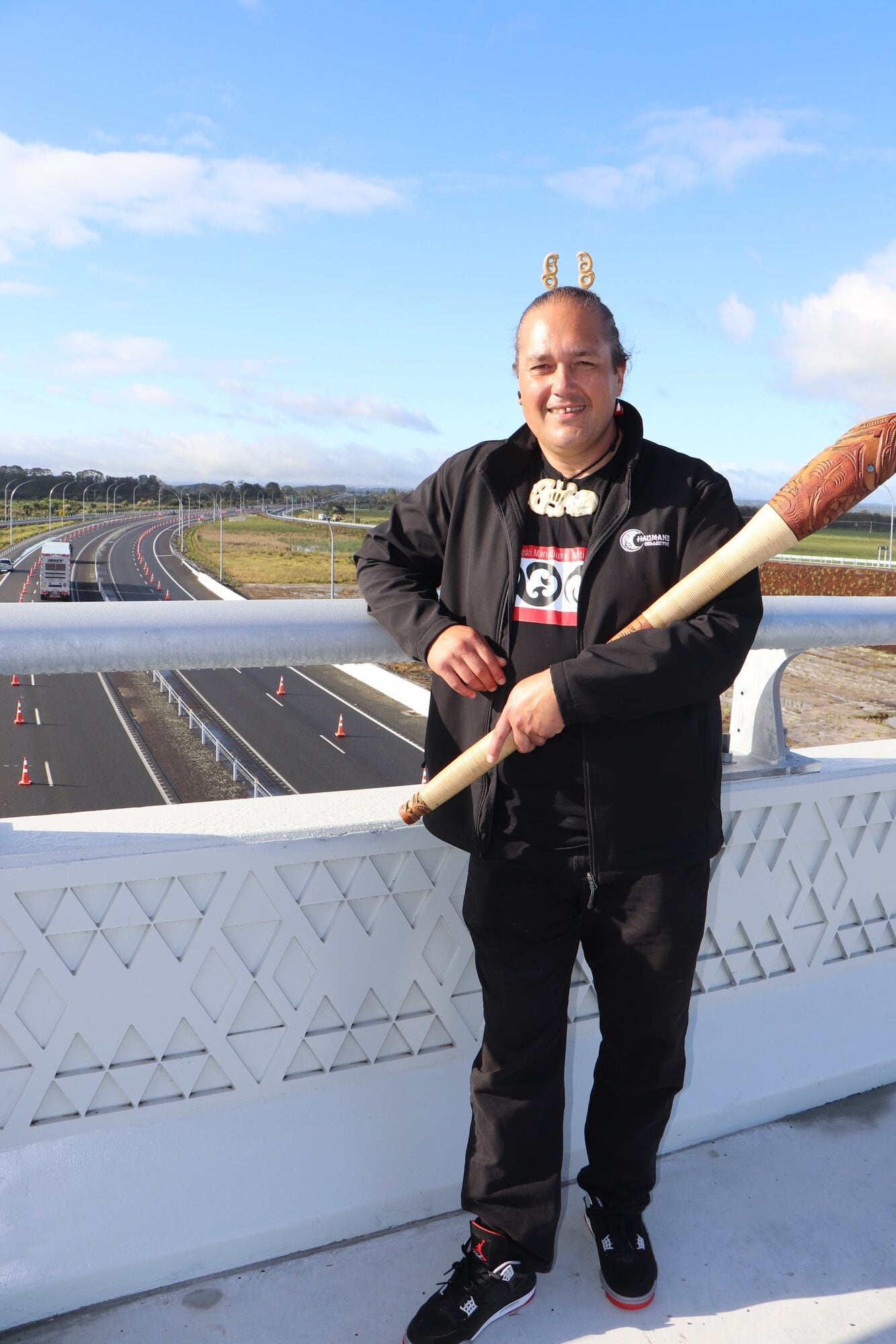 Jo'el Komene in front of the bridge barriers that have a tāniko design, a pattern often seen on korowai bands worn by chiefs. Photo / Ayla Yeoman