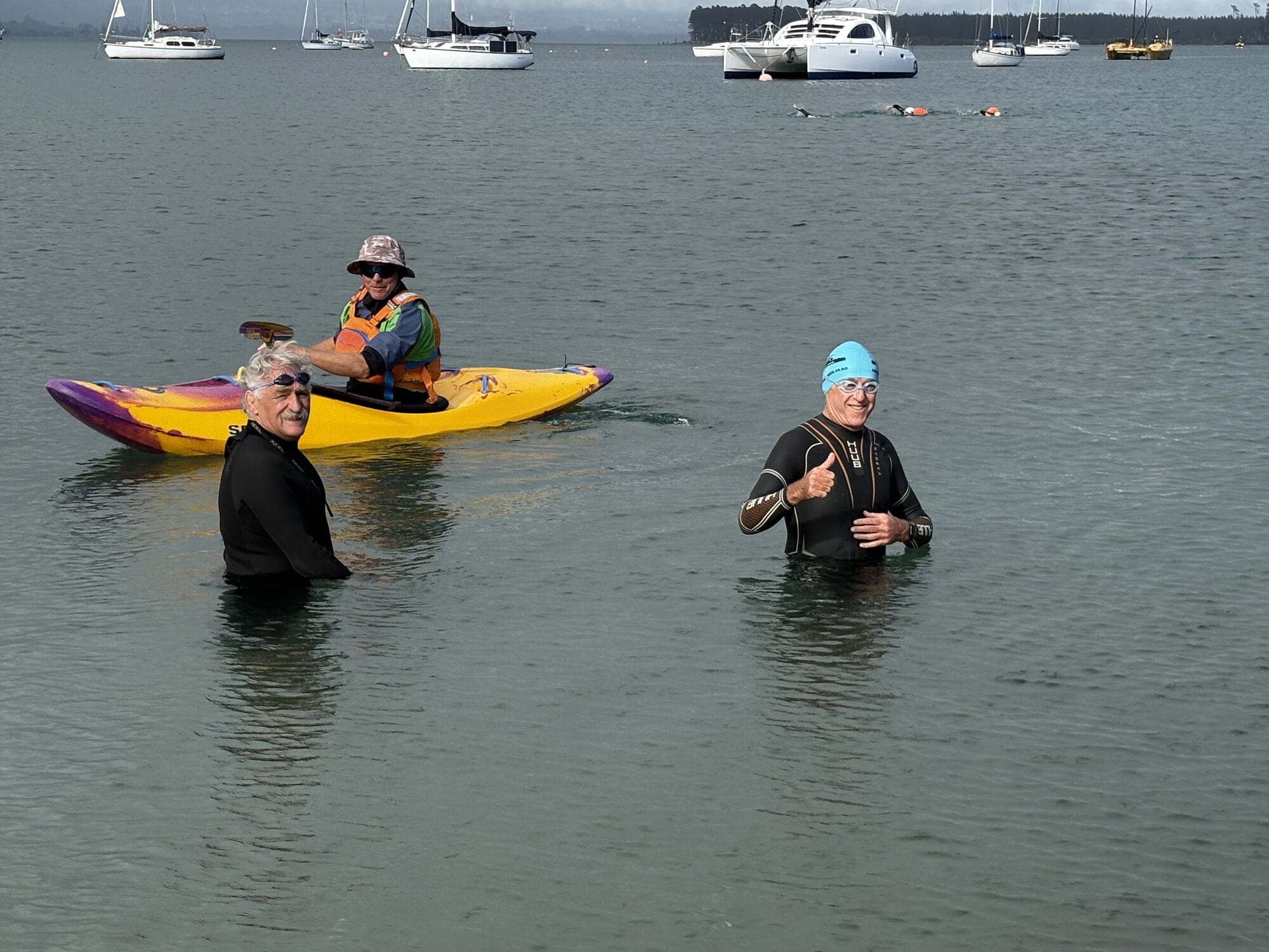  Ocean swimmer Rex Harding, Andy Windle in the kayak, and blue-capped John Mathewson after completing a swim around Mauao. Photo / Supplied