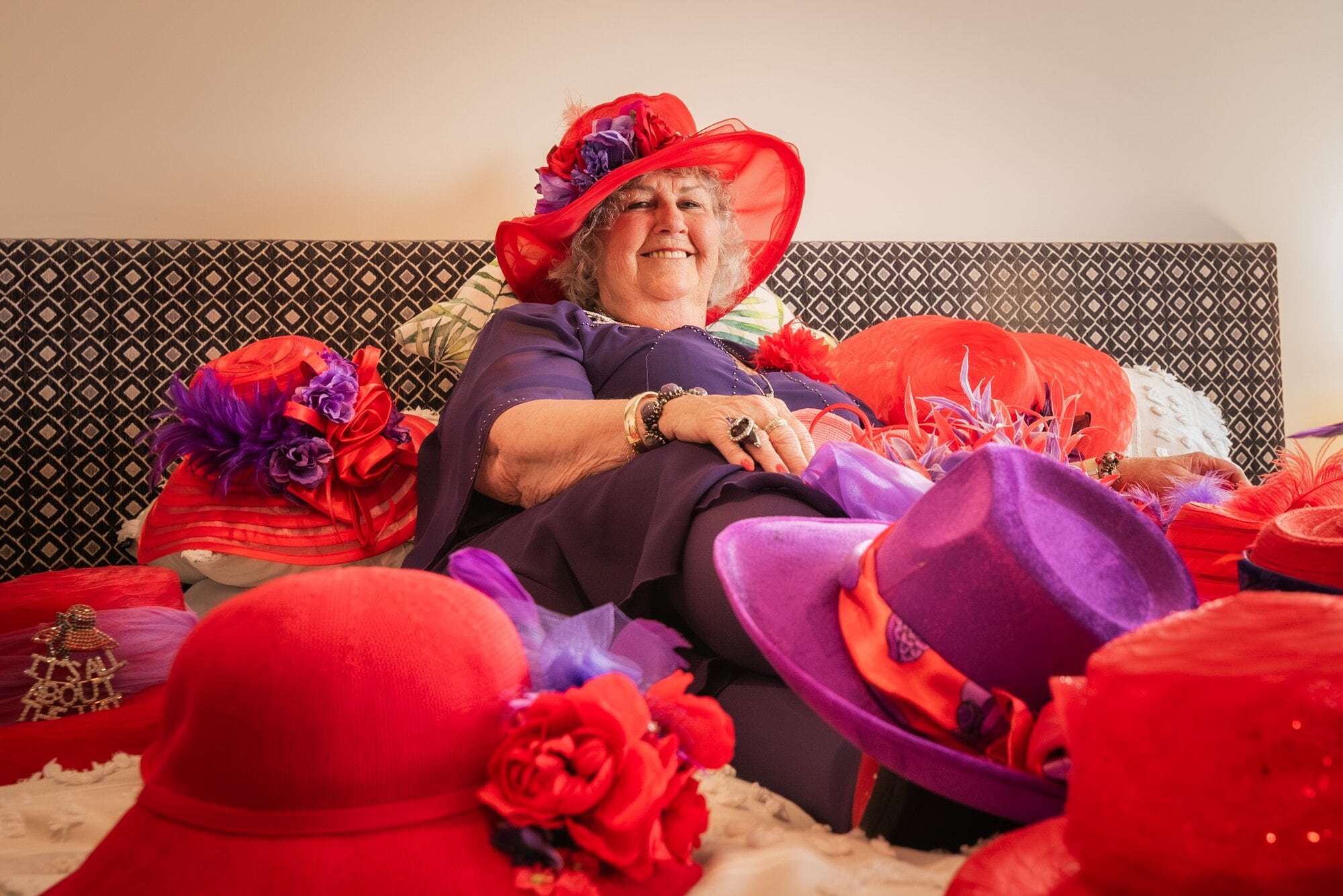  Colleen Percy photographed among her red hats for 2024’s competition by Chris Burr.