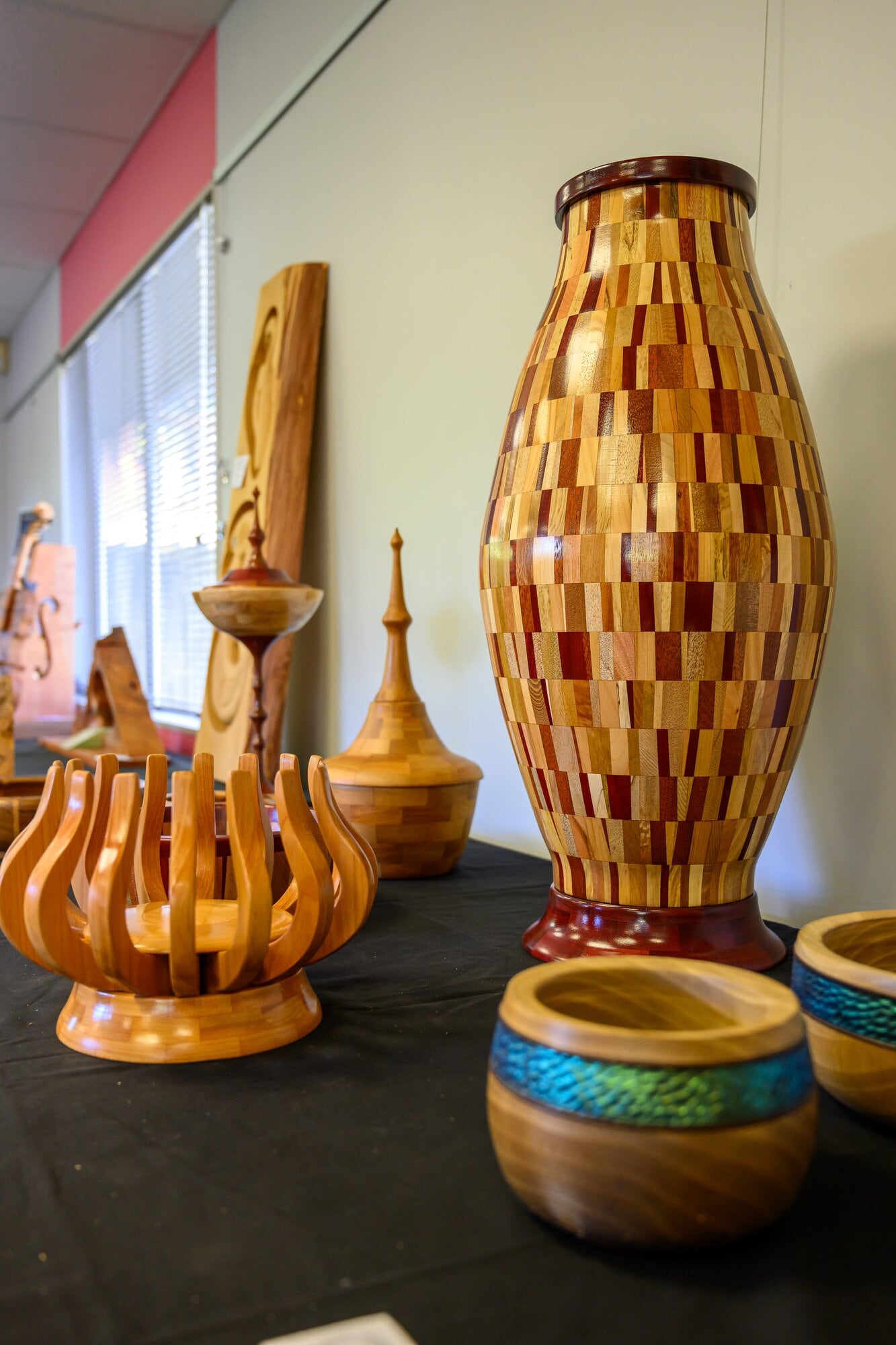 A tall wooden segmented vase on display with wooden bowls in the Tauranga Woodcrafters Guild exhibition at Tolo in Ōmokoroa. Photo / David Hall