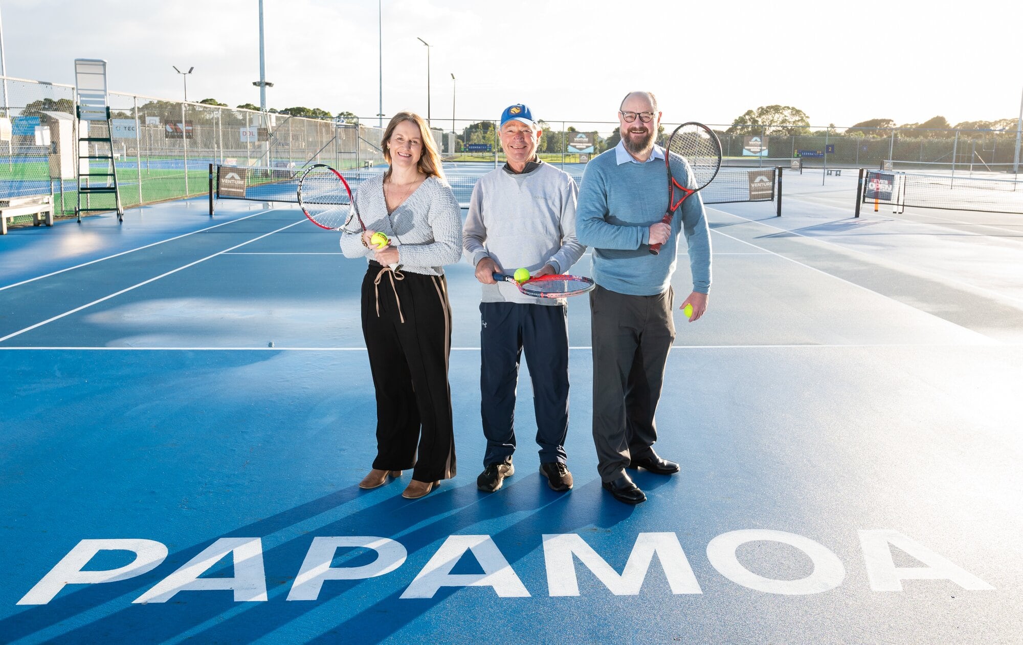  EVES Pāpāmoa general manager Meagan Swainson, Pāpāmoa Tennis Club president Gerald Greig and Pāpāmoa Ward Councillor Steve Morris can’t wait for the EVES Open to return this December. Photo / Brydie Thompson
