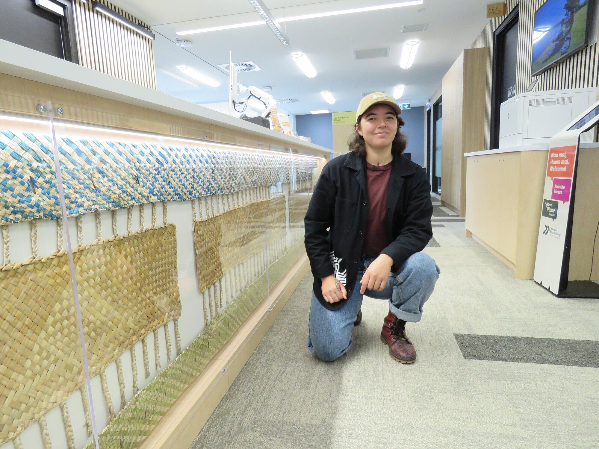  Kairāranga (weaver) Marino Magee, who grew up in Athenree, with their piece named ‘Ngā Tikanga o te Taiao’ at Waihī Beach’s new library. Photo / Merle Cave