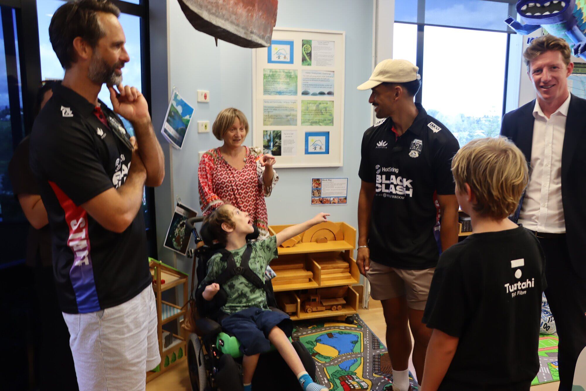  Team Cricket's Grant Elliott (left) and William Waiirua (centre) chatted to twin brothers Daniel and Aiden and their mum at Tauranga Hospital, with Tauranga MP Sam Uffindell (right). Photo / Bijou Johnson