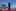 As footage from the Jan. 6, 2021, insurrection at the U.S. Capitol is displayed in the background, former President Donald Trump stands while a song, "Justice for All," is played during a campaign rally at Waco Regional Airport, March 25, in Waco, Texas. Photo / AP