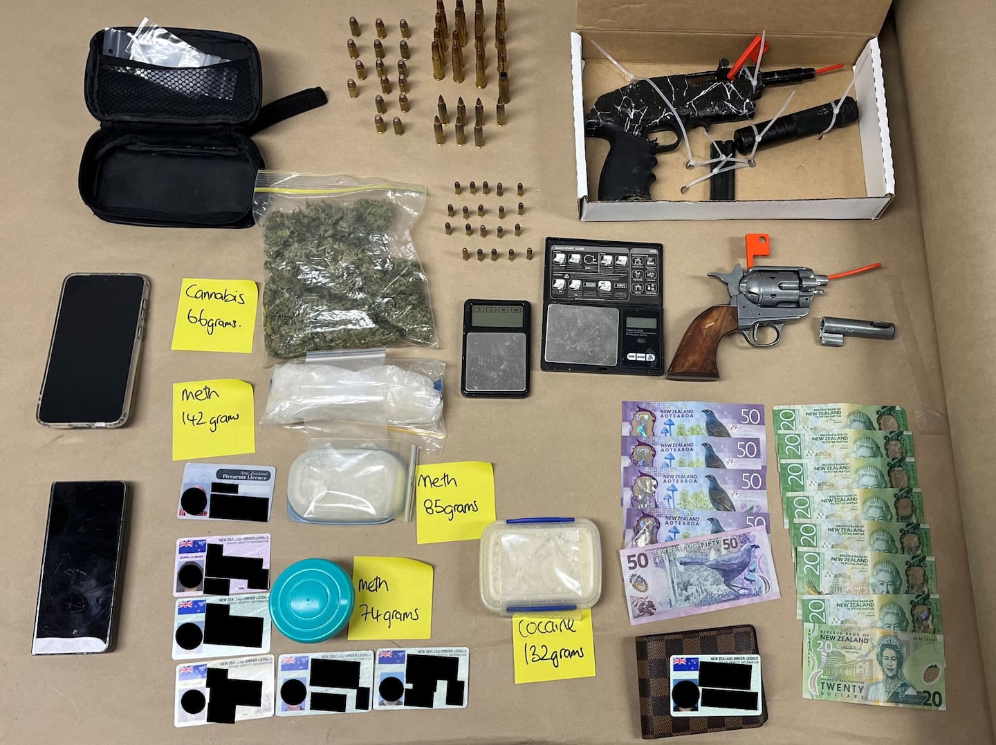 Police have seized a stash of guns, ammunition, cash and illicit drugs in raid in Central Auckland this morning, with two people facing charges. Photo / NZ Police