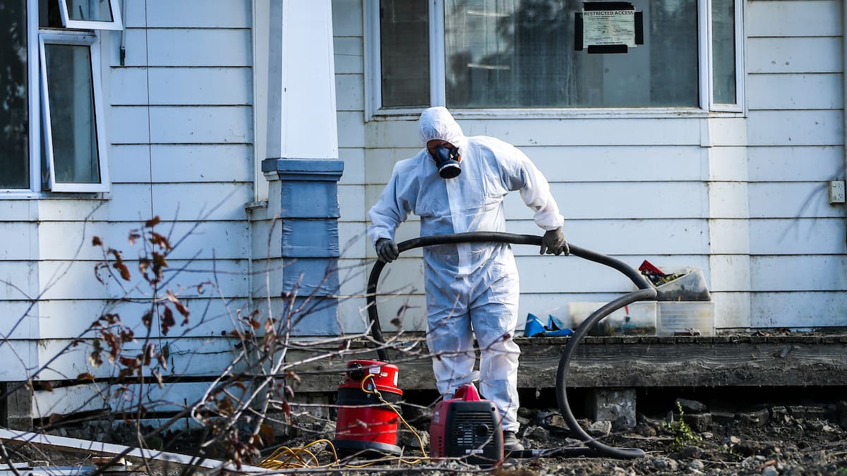 Asbestos removal begins at the first Category 3 home to be demolished in the region on Gilbertson Rd in Pākōwhai. Photo  / Paul Taylor