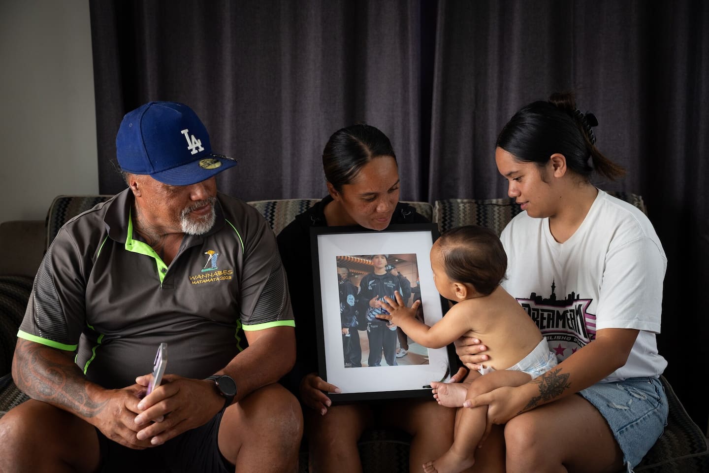 Gee Nathan and his children Kerry, baby Kai, and Honey with a photo of the late Tristyn Nathan. Photo / Sylvie Whinray