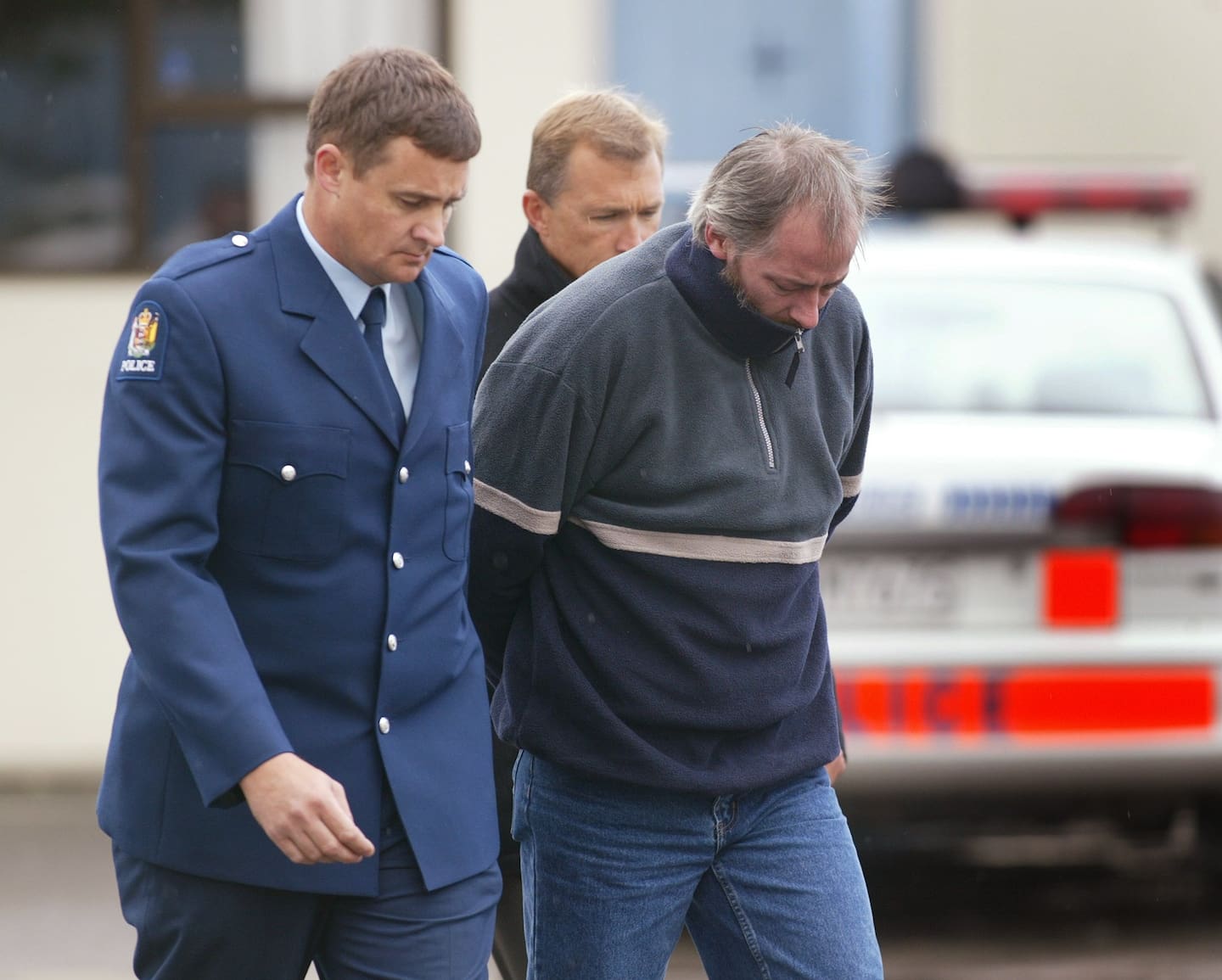 Double murderer Bruce Howse is escorted by police officers into the Masterton District Court in 2002. Photo / Mark Mitchell