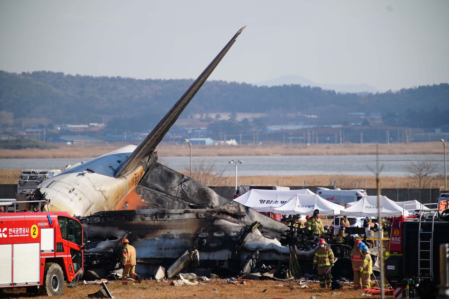 Rescue personnel at the tail section of a Jeju Air plane after it crashed and burst into flames at Muan International Airport. Photo / YONHAP, AFP