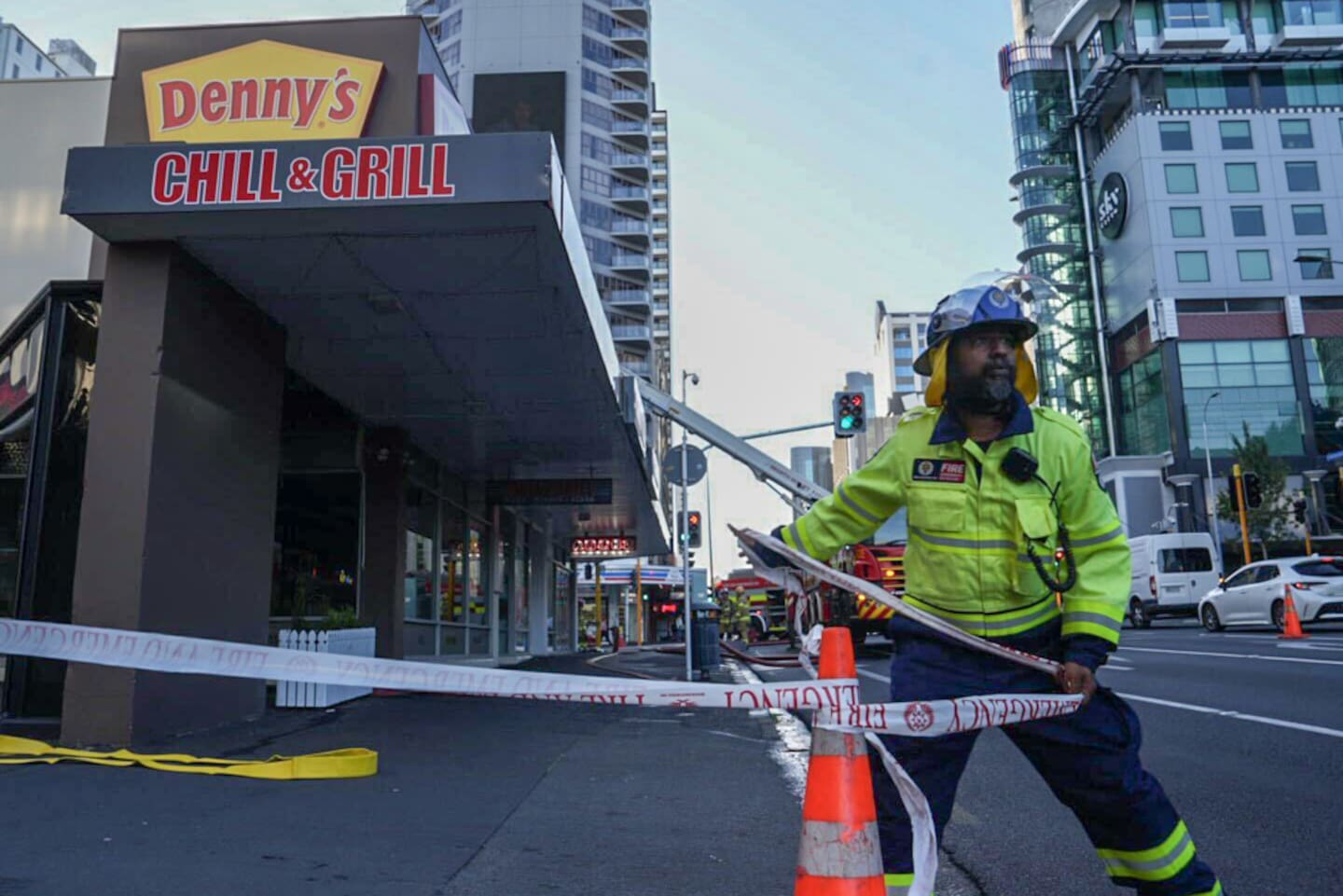 Firefighters secure the perimeter and redirect traffic as they respond to a fire in the central city during Auckland's morning commute. Photo / Anna Heath