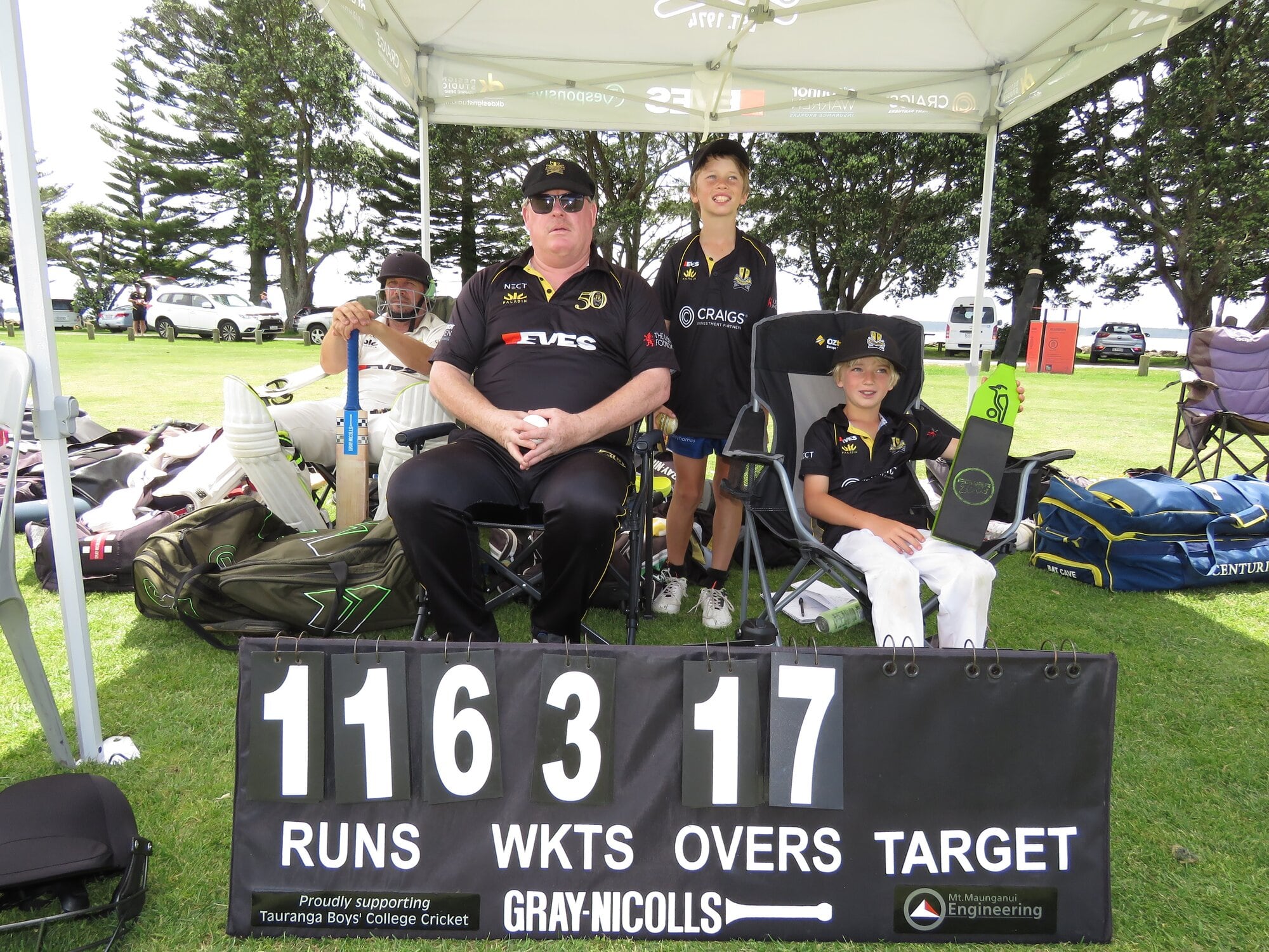  Scott Drabble in a happy place under the Greerton Gazebo, with teammate Rob Veltmans on left, and junior supporters Mason Clarke and Blake Clarke. Photo / Merle Cave