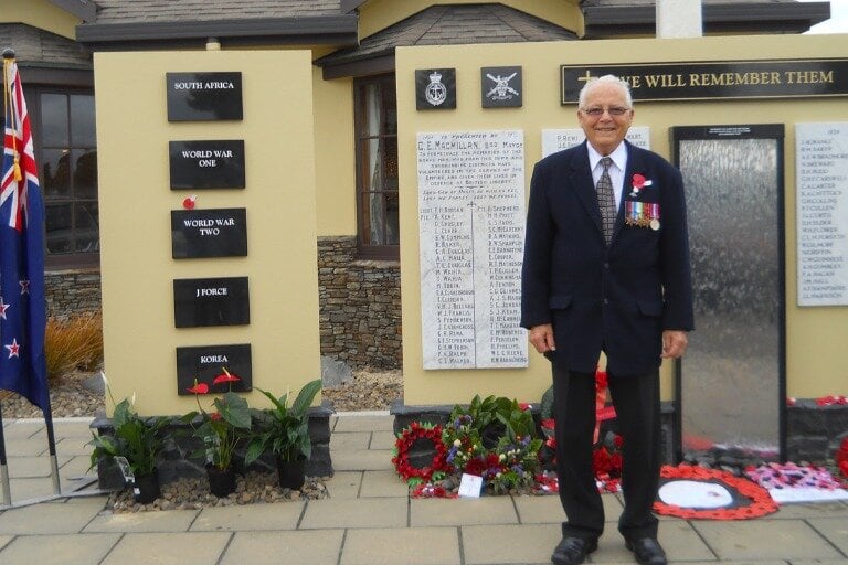 Royal Navy, World War II veteran John Clark stands in front of the Tauranga RSA Cenotaph following the Anzac parade in 2015. John enlisted in March 1942, just before his 17th birthday, and served aboard HMS Suffolk as a signalman and telegraphist during the war. Photo / Supplied