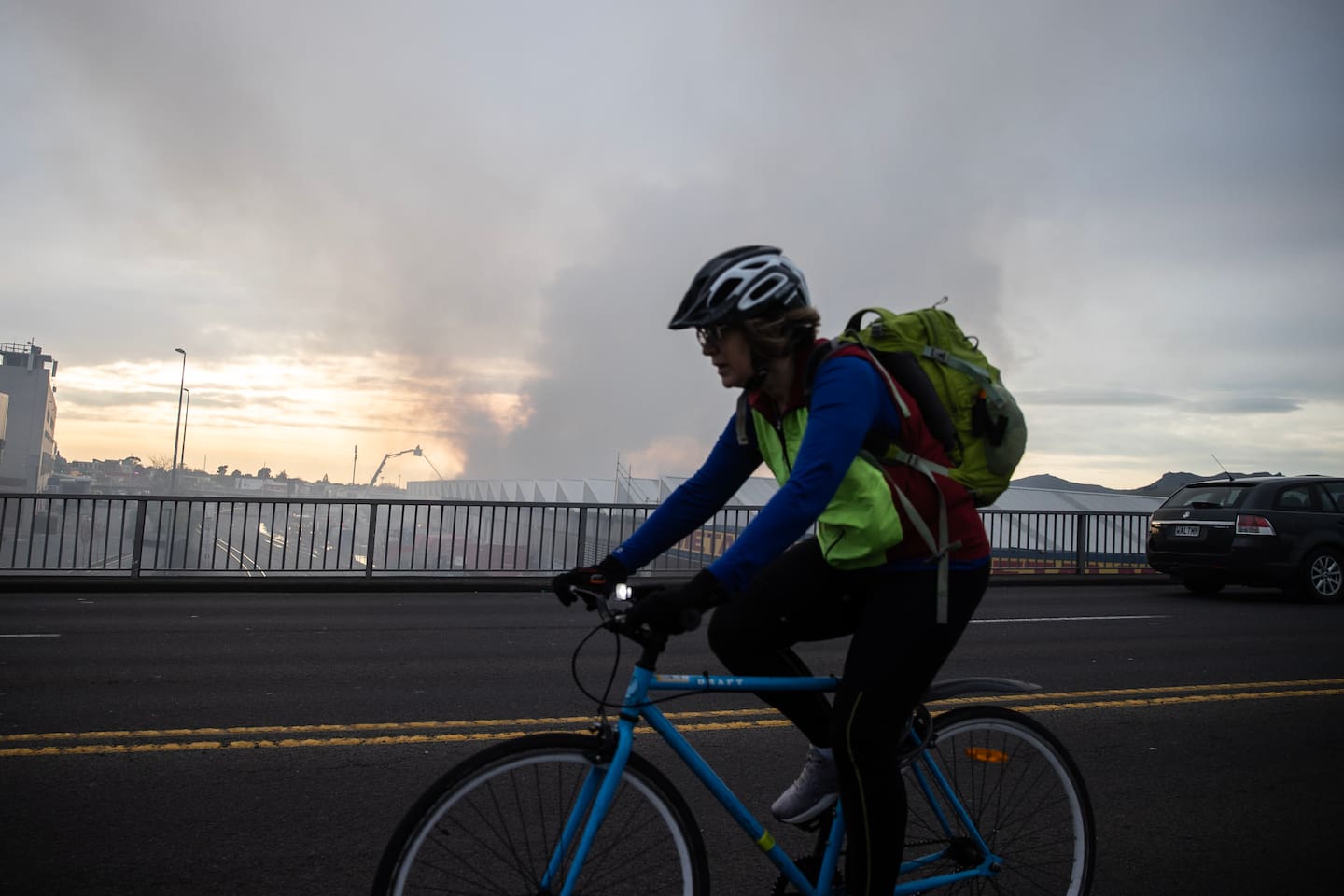 A cyclist passes the Christchurch fire at Auto Inspection Services on Colombo St. Photo / George Heard