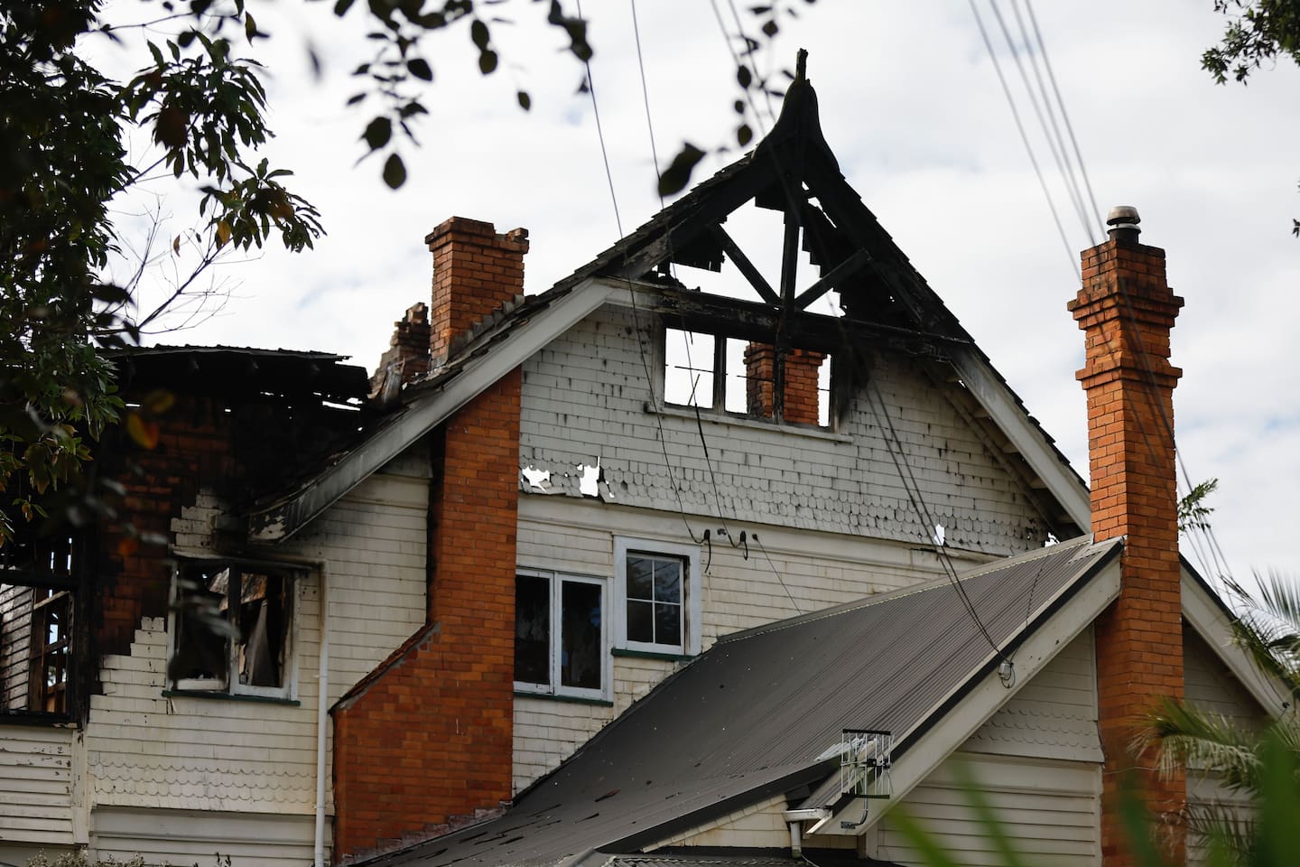 Neighbours say three men were seen fighting at the front of the burning St Georges Bay Rd property.