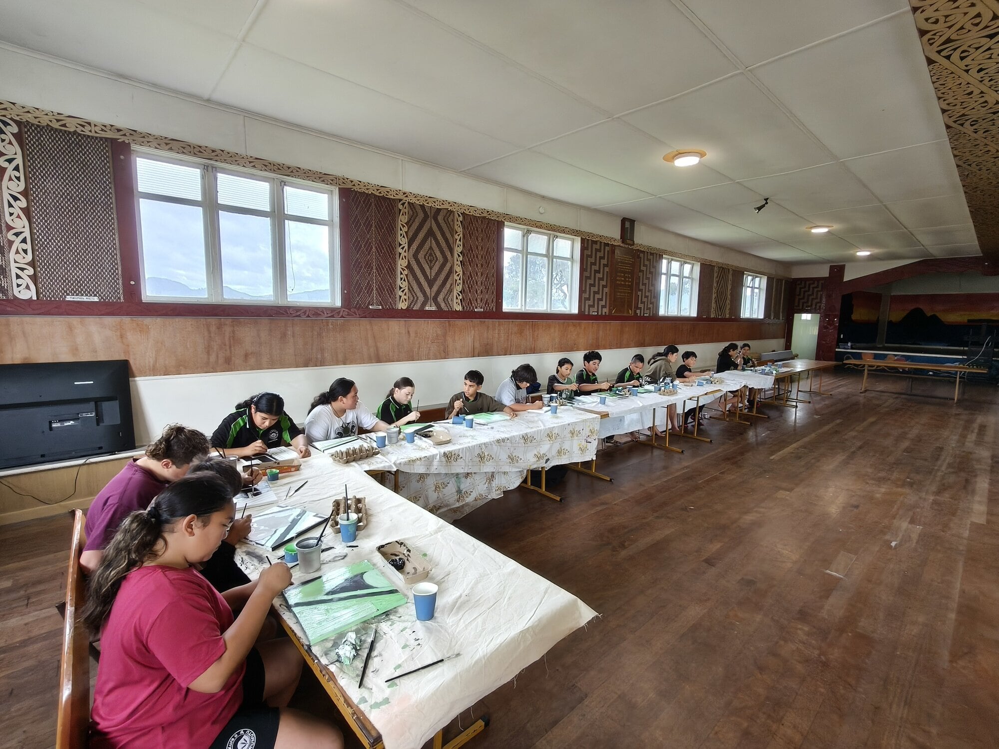 Tamariki from Whaea Maora's class aged 10-12 learn about tukutuku designs while using the paint on canvas technique at Ōmarumutu marae. Photo / Supplied