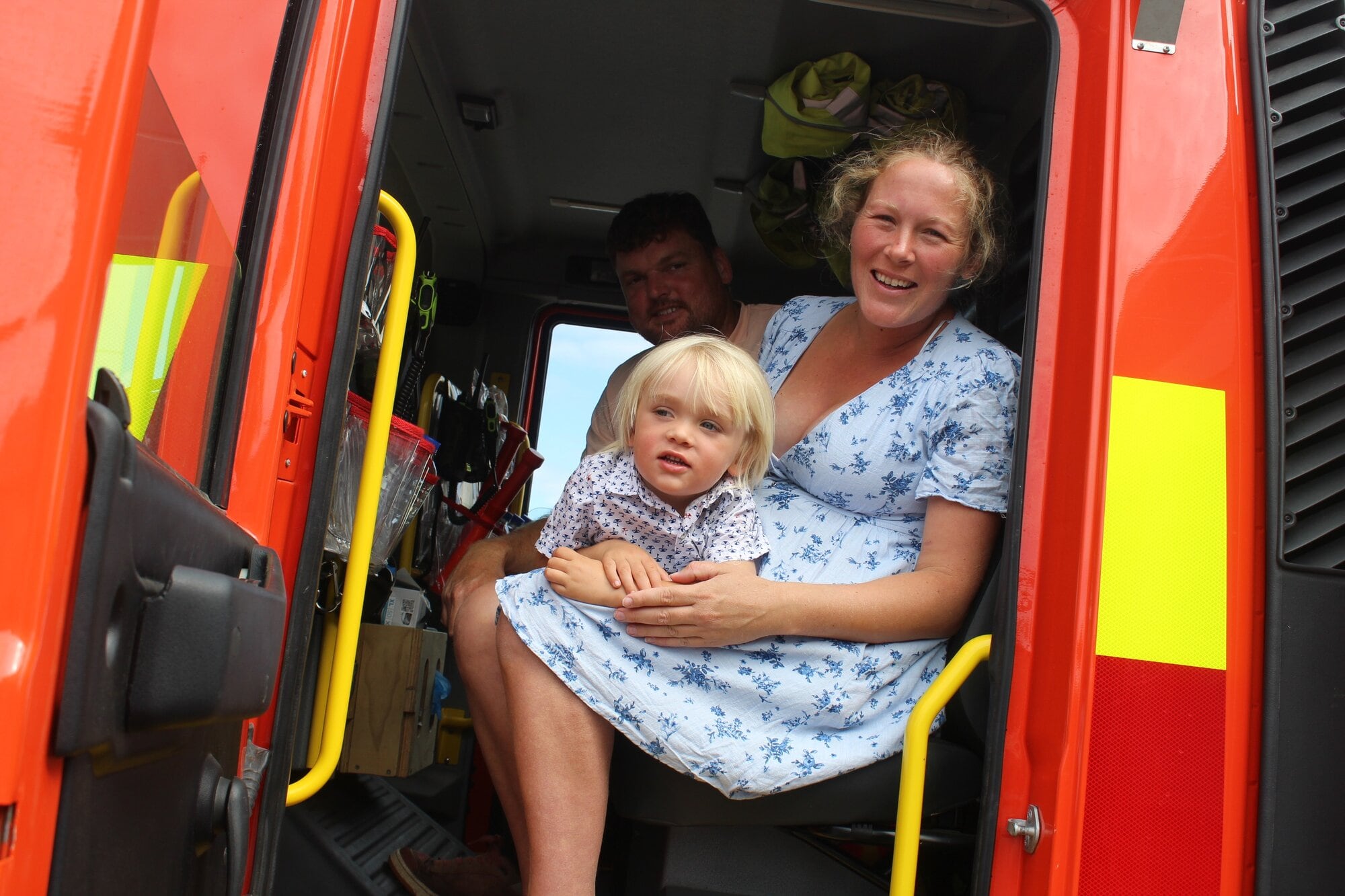 Zion Randles, 2, relaxes in the fire truck with mum Maree Fitzgerald and dad Dale Randells. Photo / Rebecca Mauger