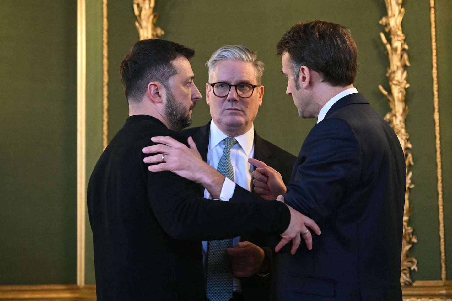 From left,  Ukraine's President Volodymyr Zelenskyy, Britain's Prime Minister Keir Starmer and France's President Emmanuel Macron embrace after holding a meeting during a summit at Lancaster House in central London on March 2, 2025. Photo / AFP