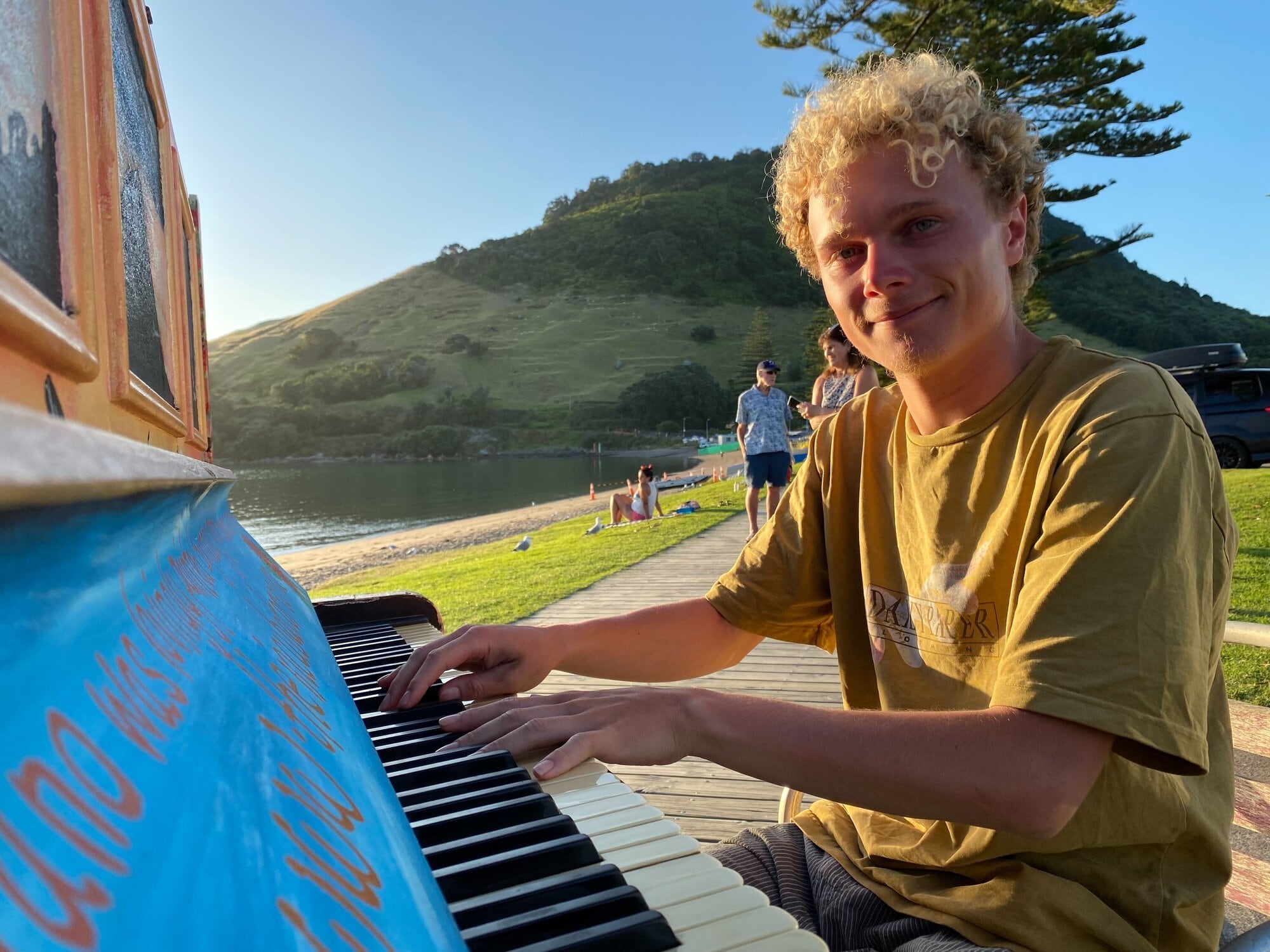 Harry Carpenter playing the Mount Maunganui beach piano in Pilot Bay. Photo / Rosalie Liddle Crawford