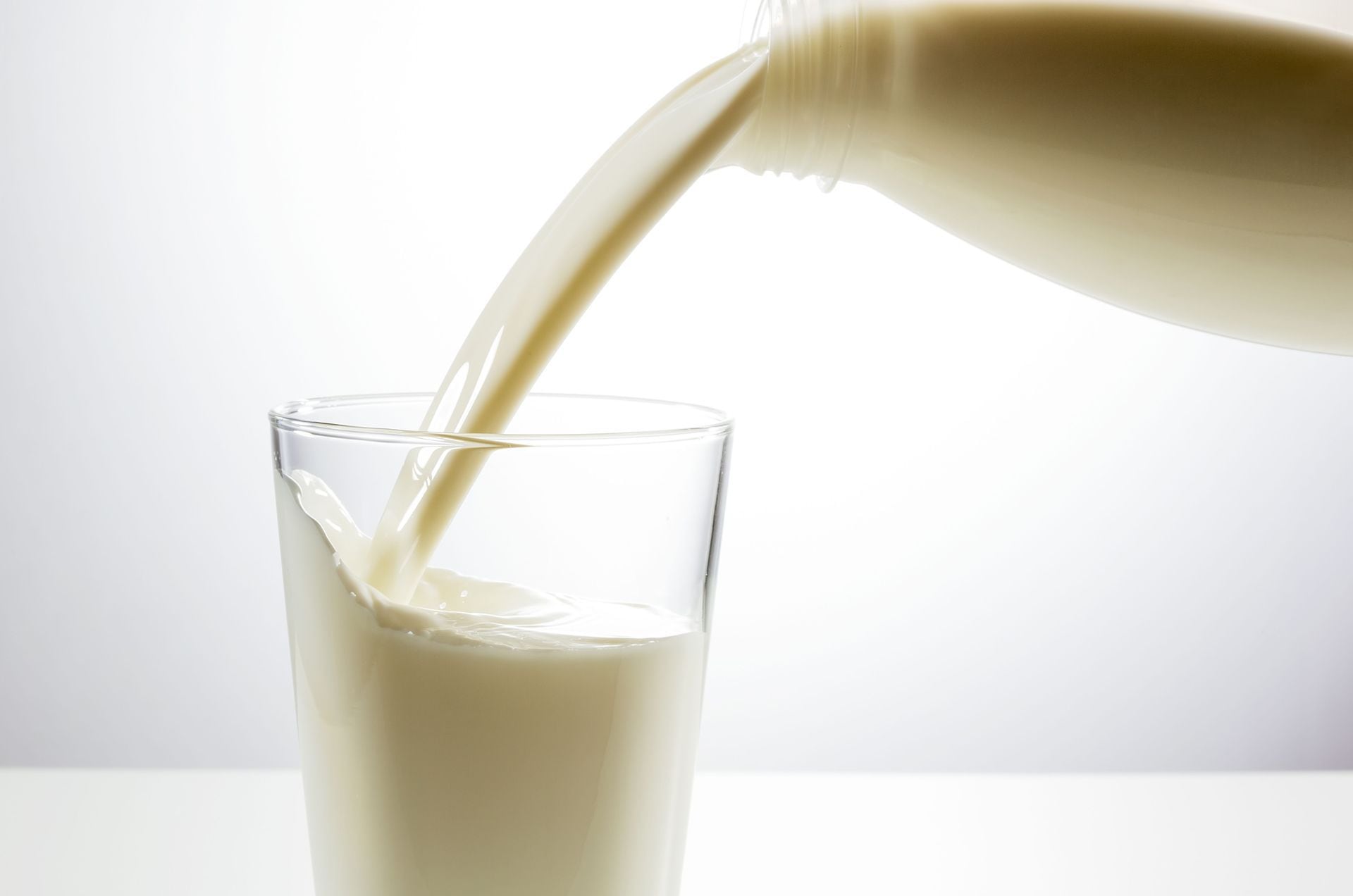 There are some milk in the glass. Стекающее молоко. Стакан молока на желтом фоне. Молоко.от.жажды.