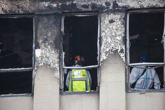 A specialist team faces challenging conditions inside Loafers Lodge, including burnt debris built up to 1 metre high on floors. Photo / George Heard