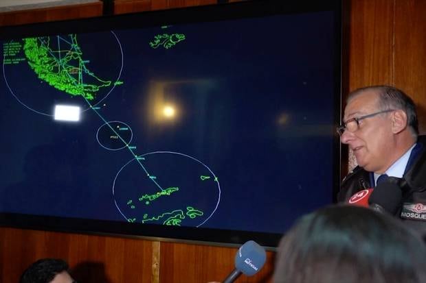 General Eduardo Mosqueira, right, of the Fourth Air Brigade, next to a map of the area where the plane is missing. Photo / AP 