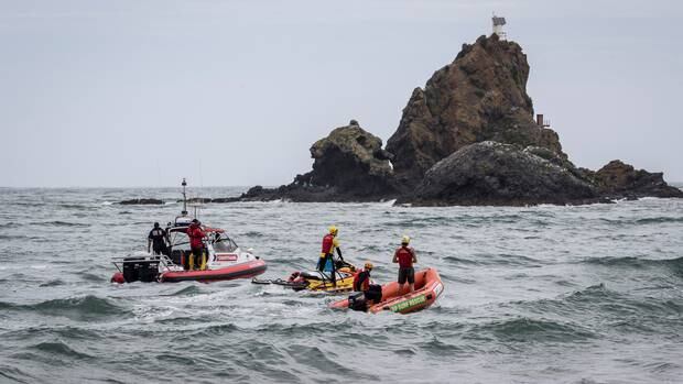 Emergency services searching for teenager Leka Pasiaka in December. In the background is Ninepin Rock, where a fisherman was swept away by large waves yesterday. Photo / Michael Craig 