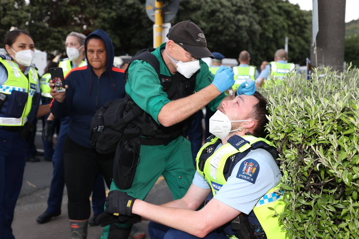 一名医护人员在抗议现场照顾一名警察。 照片/乔治·赫德