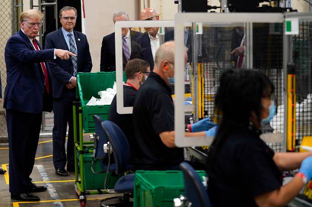 President Donald Trump (no mask) and all workers (masks). Photo / AP