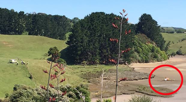 Emergency services arrive at the scene where a light aircraft lies crashed on the mudflats at Raglan. Photo / Belinda Feek